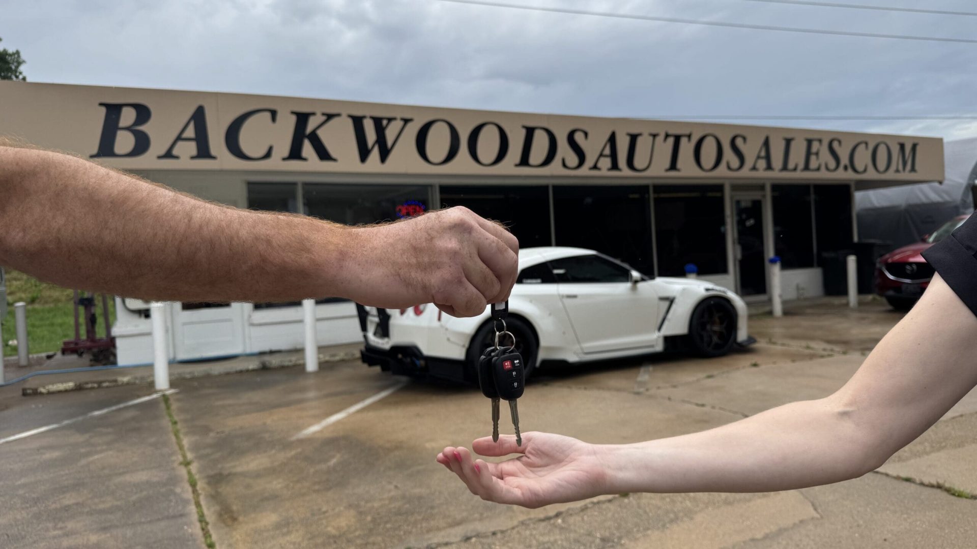 Backwoods Auto Sales handing keys to a customer